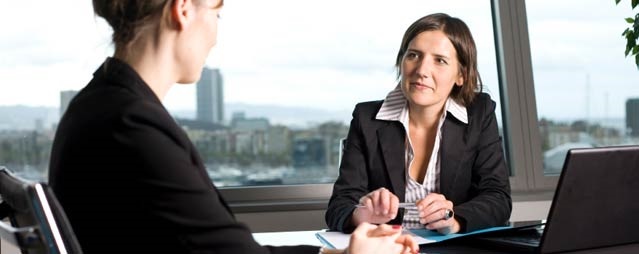 Two employees meet in conference room.